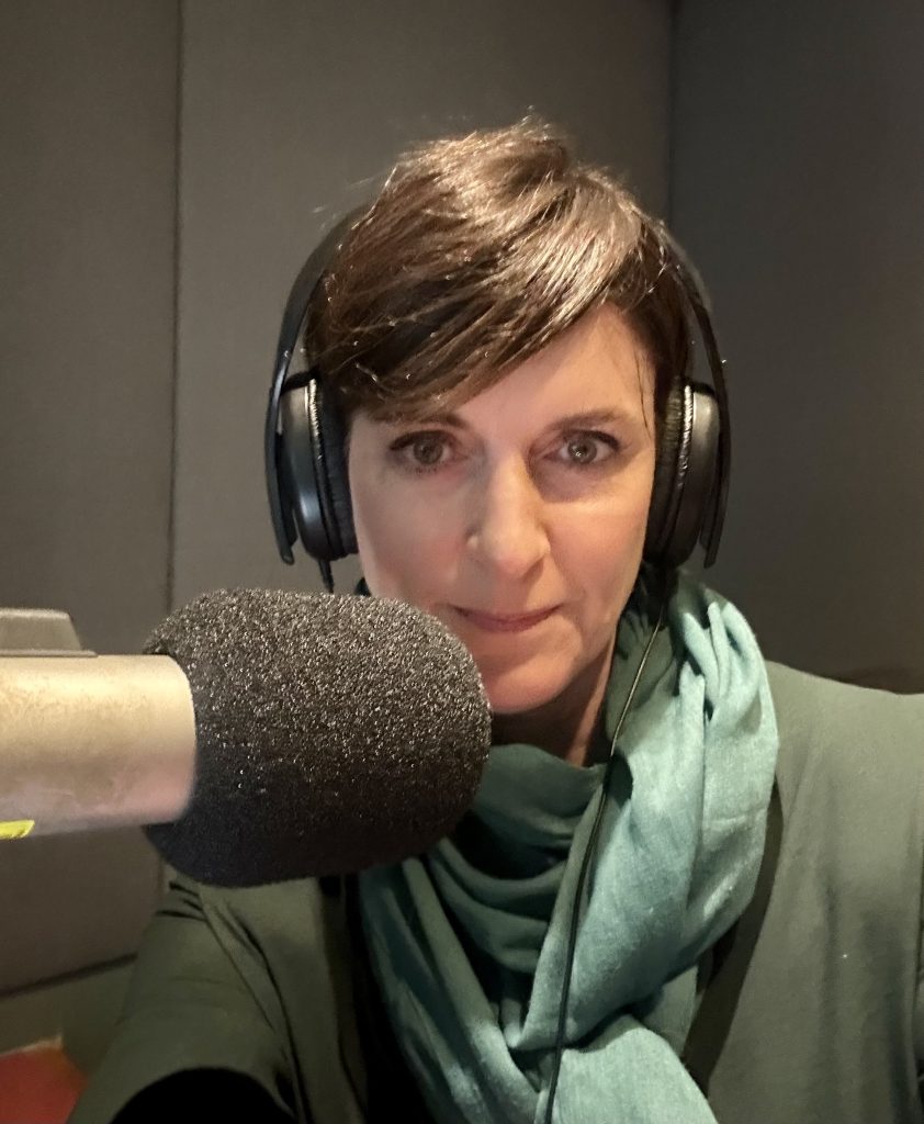 A photo of Robyn Whitaker in front of a microphone