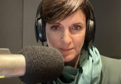 A photo of Robyn Whitaker in front of a microphone